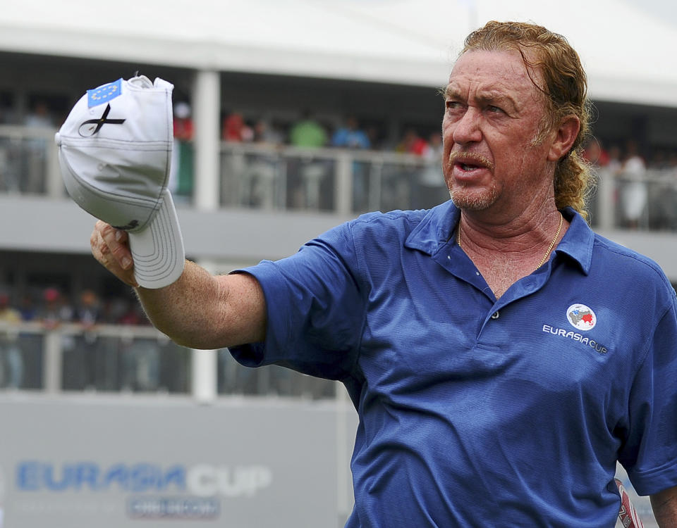 Miguel Angel Jimenez of Spain acknowledges the gallery after sinking a birdie putt on the 18th green to secure a win for his Team Europe during the third round of the EurAsia Cup golf tournament at the Glenmarie Golf and Country Club in Subang, Malaysia, Saturday, March 29, 2014. (AP Photo/Joshua Paul)