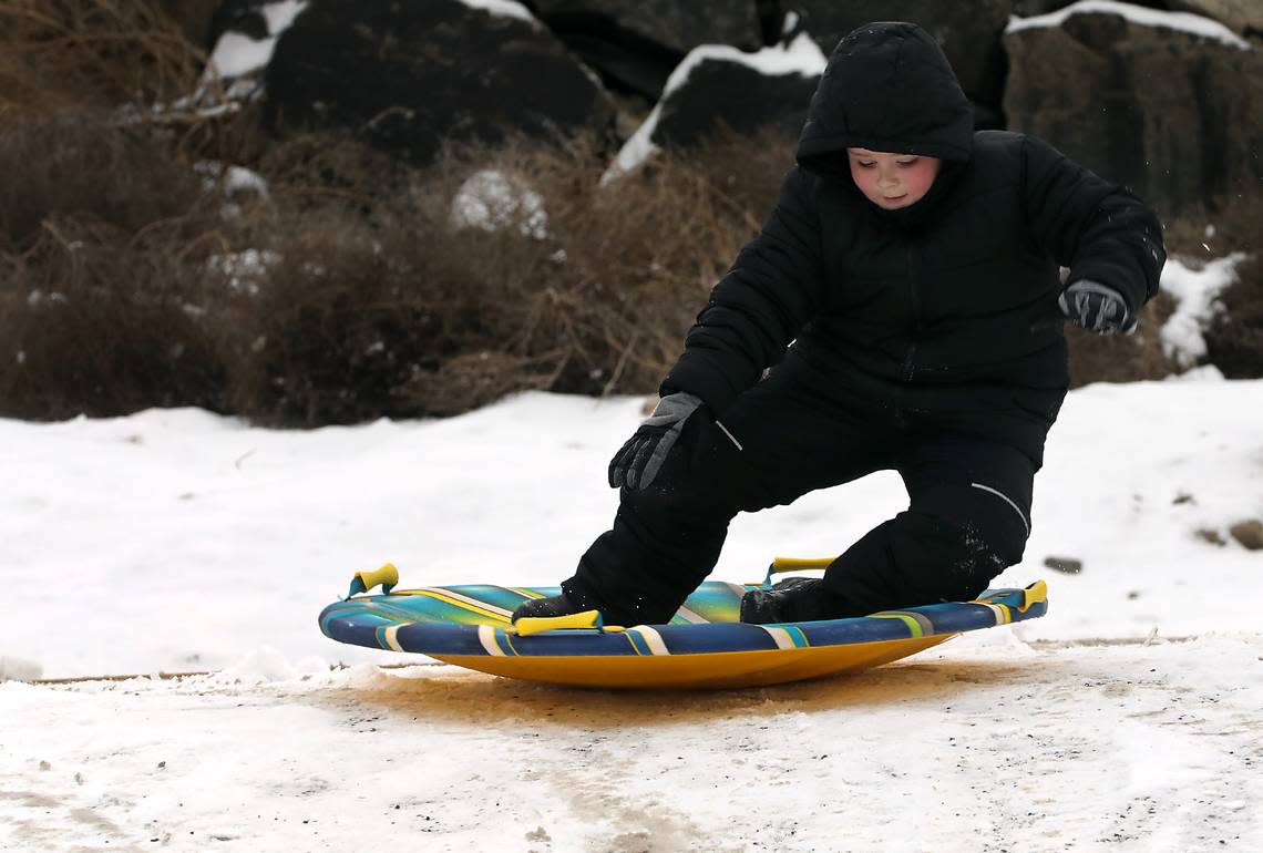 The thin layer of snow coating a short driveway is still slippery enough for Enzo Rockne, 6, to have some outdoor winter fun under the watchful eyes of his grandfather, Kevin Zarndt, Thursday in Kennewick.