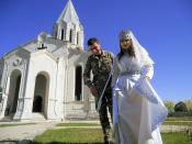 Newlyweds, soldier Hovhannes Hovsepyan, left, and Mariam Sargsyan walk after their wedding ceremony in the Holy Savior Cathedral, damaged by shelling by Azerbaijan's artillery during a military conflict in Shushi, the separatist region of Nagorno-Karabakh, Saturday, Oct. 24, 2020. The wedding was celebrated even as intense fighting in the region has continued. (AP Photo)
