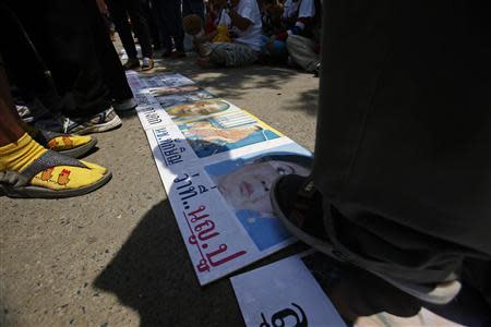 Anti-government protesters step on a poster of ousted Thai prime minister Yingluck Shinawatra outside the National Broadcast Services of Thailand (NBT) television station in Bangkok May 9, 2014. REUTERS/Athit Perawongmetha