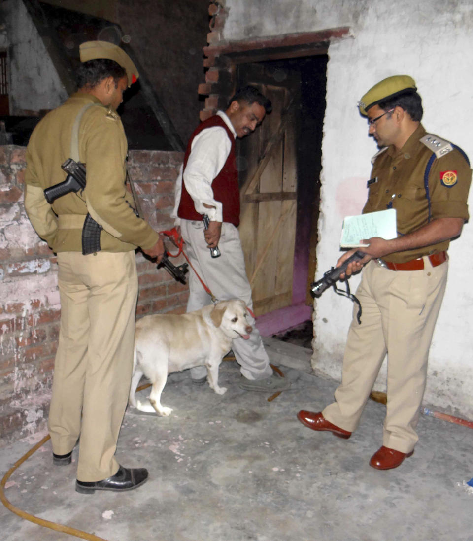 In this Thursday, Feb. 20, 2014, Indian policemen investigate with sniffer dog at Bunty Sharma, 32, an auto rickshaw driver, house, in Agra, India. Bunty fatally stabbed his American wife Erin W. Willinger before killing himself in Agra, the city that is home to the Taj Mahal and where the couple married in October, police said Saturday. Willinger's body was found with multiple stab wounds late Thursday night in a deserted part of the city, said Agra police chief Shalabh Mathur. Her husband Bunty Sharma committed suicide by igniting cooking gas and causing a massive explosion in his home, Mathur said. (AP Photo)