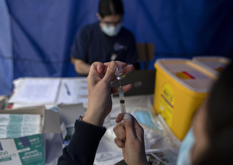 Un trabajador de la salud prepara una dosis de la vacuna Sinovac para el COVID-19 en un sitio de vacunación en el estadio Nacional en Santiago, Chile, el martes 16 de marzo de 2021. (AP Foto/Esteban Félix)