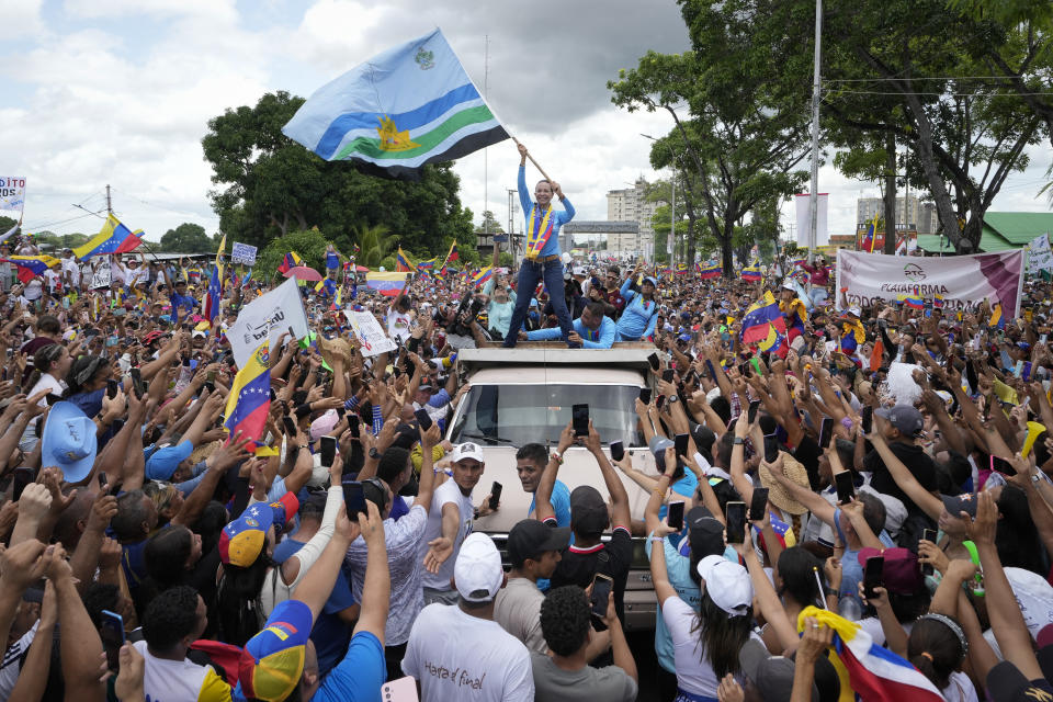 La líder opositora venezolana María Corina Machado ondea una bandera del estado de Monagas mientras saluda a sus partidarios durante un acto de campaña por el candidato presidencial Edmundo González, in Maturín, Venezuela, el sábado 20 de julio de 2024. Las elecciones presidenciales el 28 de julio. (AP Foto/Matias Delacroix)