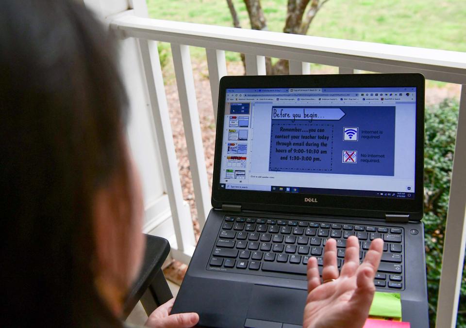 North Pointe Elementary teacher and parent Lani Gray looks over e-learning homework material on her laptops in Anderson, South Carolina, on Monday, March 16, 2020. Gray has two children who are also assigned homework online.