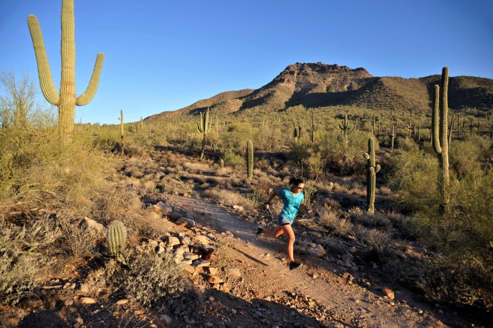 Woman trail running in Usery Mountain Park, via Getty Images