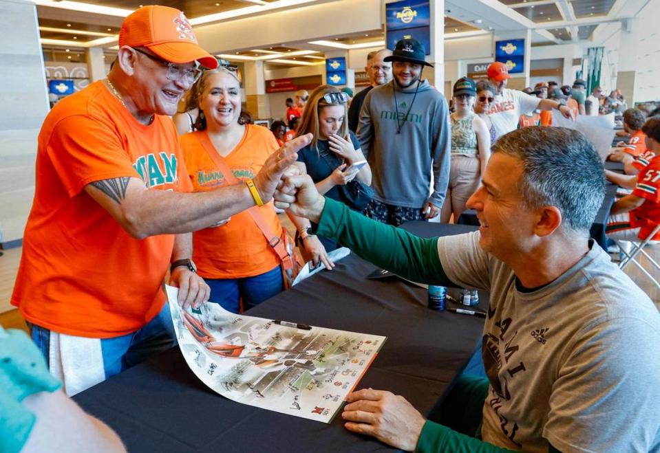 Miami Hurricanes coach Mario Cristobal fist pumps Enrique Borregales, father of Miami Hurricanes place kicker Andres Borregales (30), during the University of Miami’s annual CanesFest at Hard Rock Stadium in Miami Gardens on Saturday, August 12, 2023.