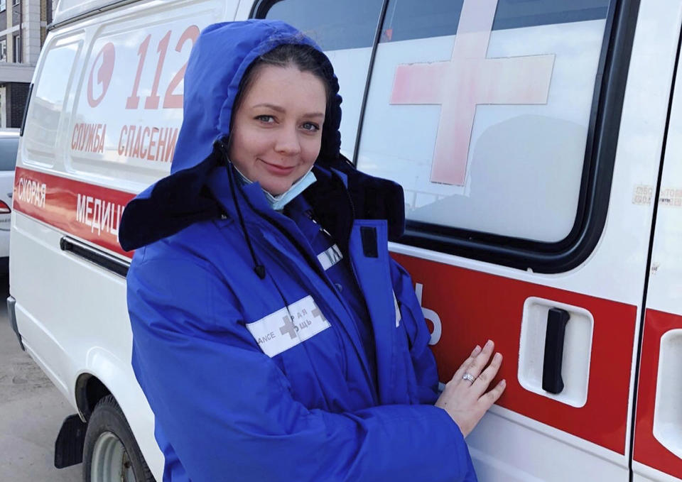 In this photo taken on March 22, 2020, Dr. Yevgeniya Bogatyryova poses for a photo next to an ambulance in Korolev, just outside Moscow, Russia. Bogatyryova, a Moscow-area ambulance medic, told AP the April bonuses varied from $2 to $120. (AP Photo)