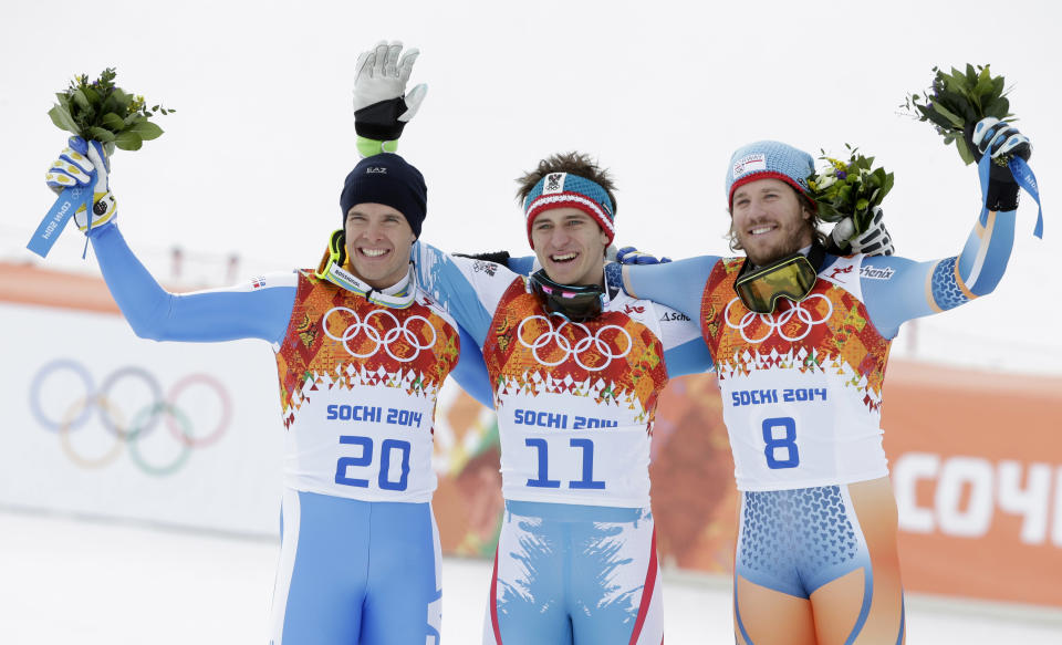 Men's downhill medalists from left, Italy's Christof Innerhofer, silver, Austria's Matthias Mayer, gold, and Norway's Kjetil Jansrud, bronze, stand on the podium at a flower ceremony at the Sochi 2014 Winter Olympics, Sunday, Feb. 9, 2014, in Krasnaya Polyana, Russia.(AP Photo/Gero Breloer)