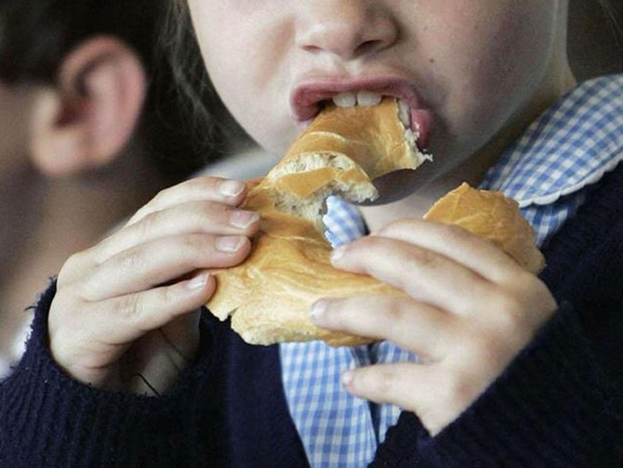 A child eating a bagel at a breakfast club as around one in six parents admit they would have leave their child unsupervised if there was not a breakfast club for them to attend before school, a poll suggests: PA