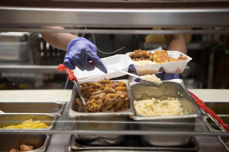 A cook serves rice onto a styrofoam container at Silver Sands Cafe in Nashville, Tenn., Tuesday, Sept. 26, 2023.