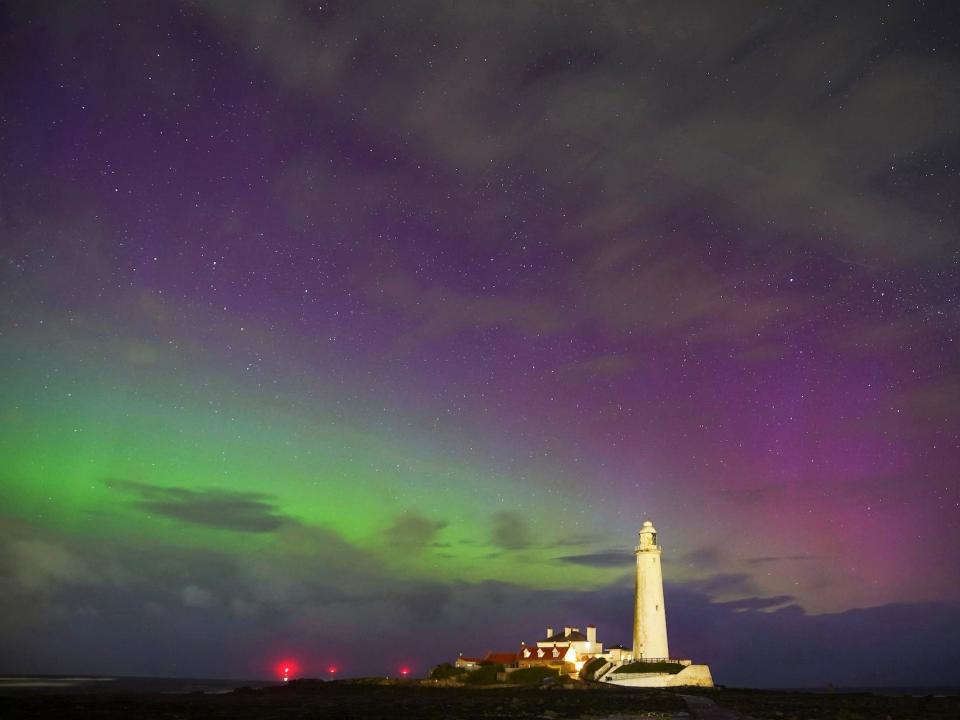 Auroras seen above a lighthouse.