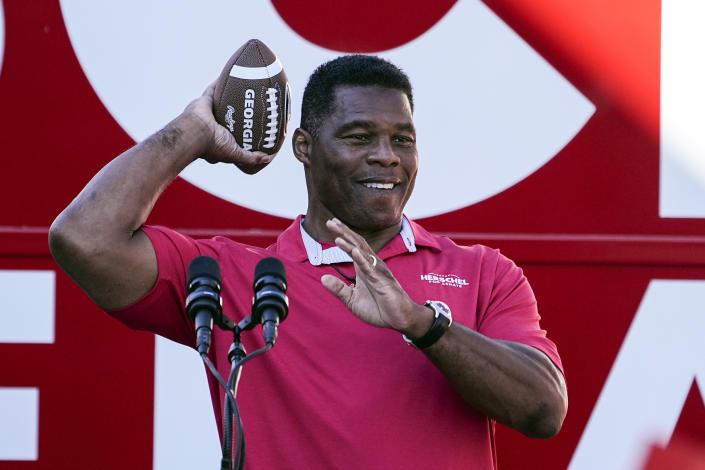 Republican candidate for U.S. Senate Herschel Walker throws a football to a supporter during a campaign rally Tuesday, Nov. 29, 2022, in Greensboro, Ga. Walker is in a runoff election with incumbent Democratic Sen. Raphael Warnock. (AP Photo/John Bazemore)