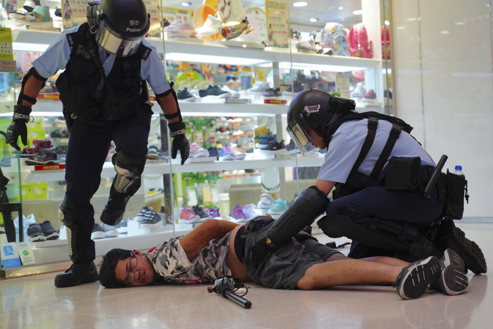 Police detain a young man after fights broke out between pro-China supporters and anti-government protesters at Amoy Plaza in the Kowloon Bay district in Hong Kong, Saturday, Sept. 14, 2019. The clashes came after several nights of peaceful rallies that featured mass singing at shopping malls by supporters of the months-long protests demanding democratic reforms. (AP Photo/Vincent Yu)