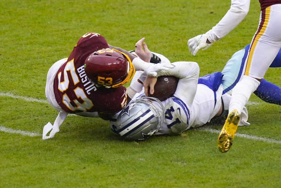 Dallas Cowboys quarterback Andy Dalton (14) collides with Washington Football Team inside linebacker Jon Bostic (53) in the second half of an NFL football game, Sunday, Oct. 25, 2020, in Landover, Md. Dalton left the field after this hit. (AP Photo/Patrick Semansky)