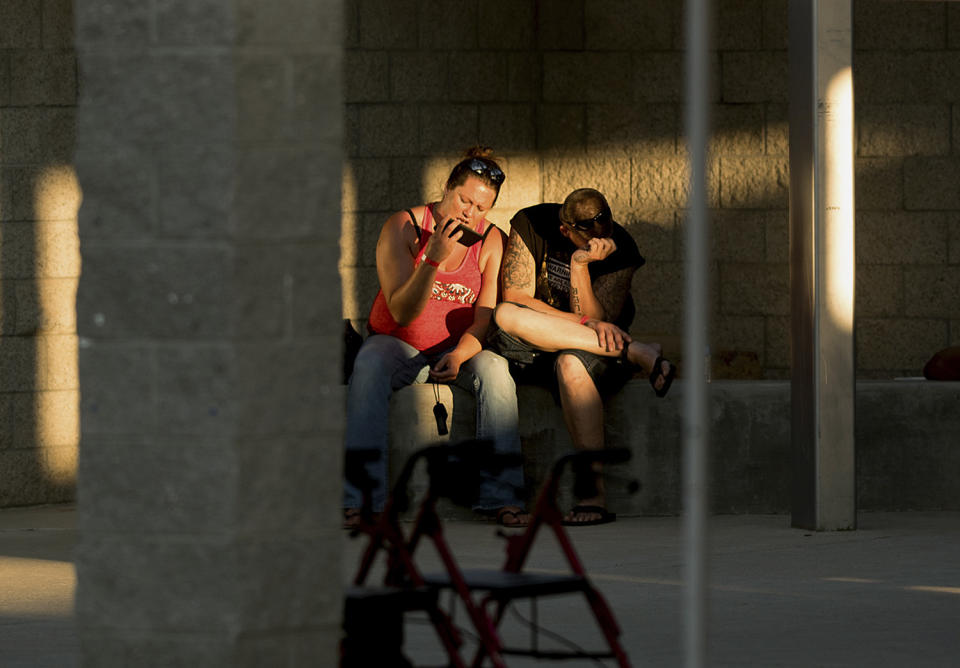 <p>Josh Cornelison and Sharon Reitan rest outside an evacuation shelter for people affected by a wildfire on Sunday, July 9, 2017, in Oroville, Calif. The couple lost their home as the Wall tore through a mountain community Friday. (AP Photo/Noah Berger) </p>