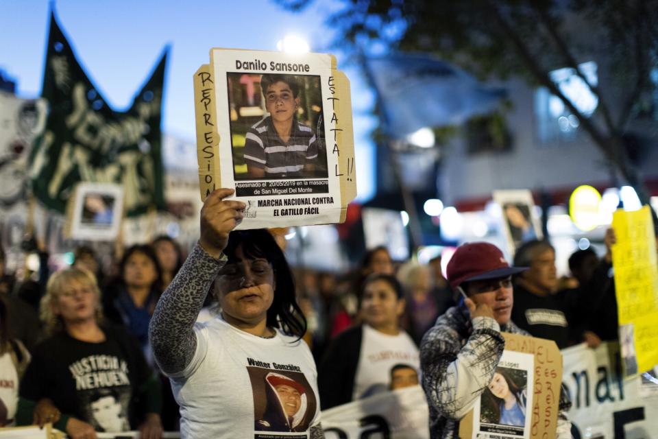 Demonstrators hold posters of the four victims of Monday's police shooting, during a march against police brutality, in Buenos Aires, Argentina, Friday, May. 24, 2019. Argentines protested after officers on Monday fired shots that led to the deaths of three teenagers and a young man in a car chase. (AP Photo/Tomas F. Cuesta)