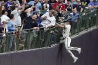 Milwaukee Brewers' Tyrone Taylor can't catch a foul ball hit by Atlanta Braves' Adam Duvall during the fifth inning of a baseball game Monday, May 16, 2022, in Milwaukee. (AP Photo/Morry Gash)