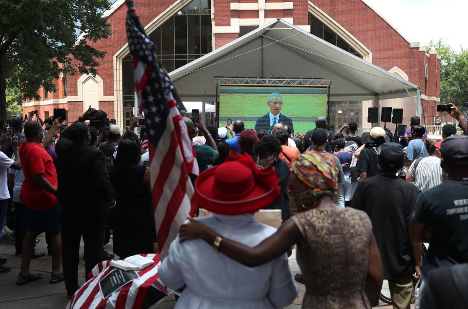 <p>Mourners watched the funeral from an overflow area outside the church. One woman held and American flag while watching President Obama give his eulogy. </p>