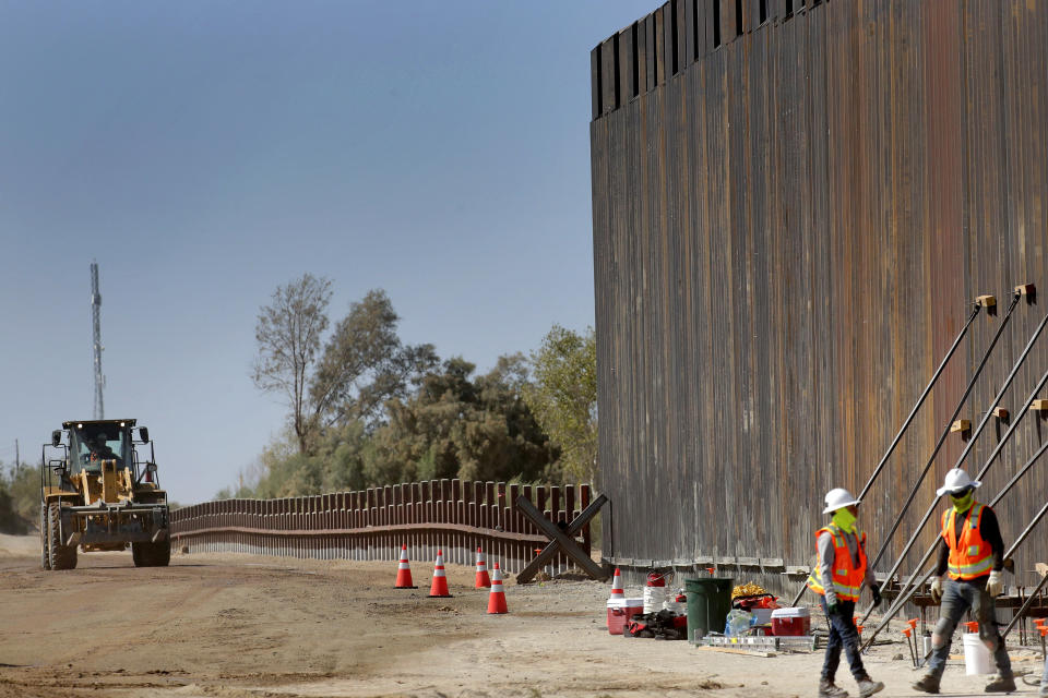 FILE - In this Sept. 10, 2019, file photo, government contractors erect a section of Pentagon-funded border wall along the Colorado River, in Yuma, Ariz. A federal appeals court hears arguments against diverting Pentagon money for border wall construction as time runs out. It says the Trump administration has moved quickly to spend the money after the Supreme Court rejected an emergency appeal to prevent work from starting in July. (AP Photo/Matt York,File)