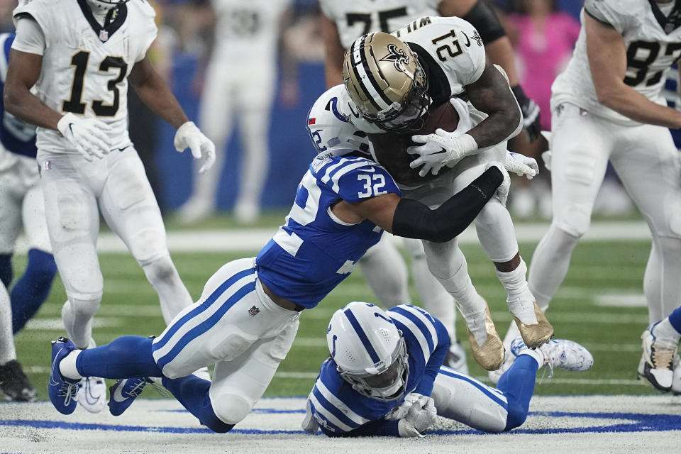 New Orleans Saints running back Jamaal Williams (21) runs the ball as Indianapolis Colts safety Julian Blackmon (32) makes the tackle during the second half of an NFL football game Sunday, Oct. 29, 2023 in Indianapolis. (AP Photo/Darron Cummings)