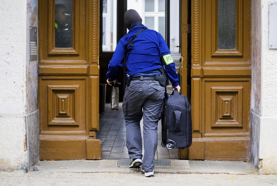 Un policía entra en una casa durante una redada en Berlín, Alemania, el miércoles 24 de mayo de 2023. Las fuerzas de seguridad allanan 15 propiedades en diferentes puntos de Alemania y confiscan activos dentro de una investigación sobre el grupo activista climático Last Generation. La fiscalía de Múnich investiga a siete personas de entre 22 y 38 años sospechosas de pertenencia o apoyo a organización criminal. (Christoph Soeder/dpa via AP)