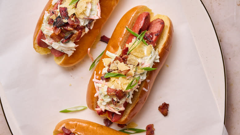 hot dogs with coleslaw, bacon and potato chips on platter