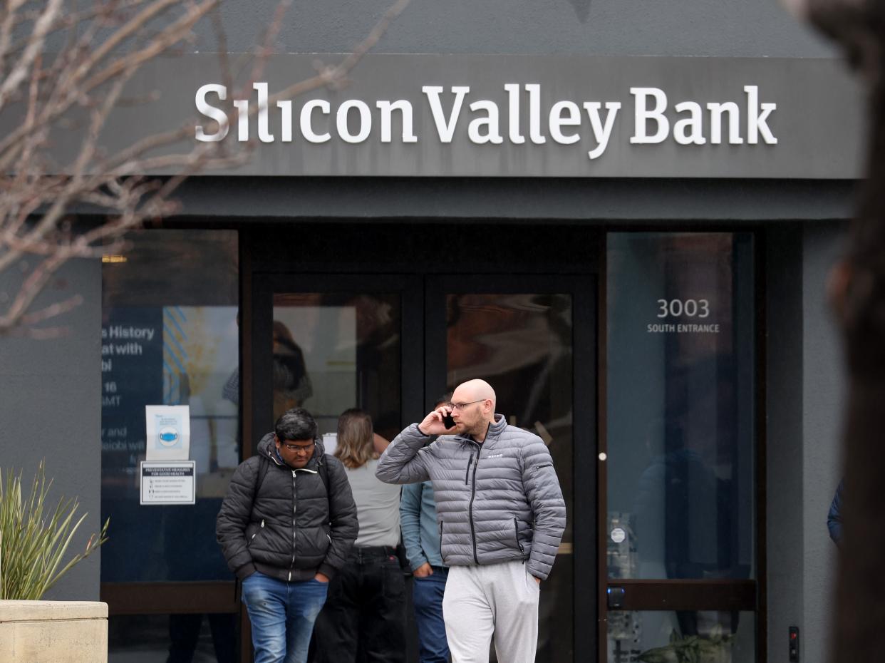 Employees stand outside of the shuttered Silicon Valley Bank (SVB) headquarters on March 10, 2023 in Santa Clara, California.