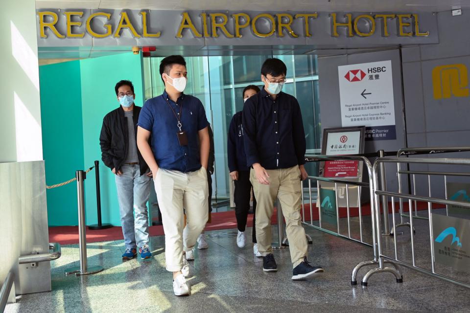 People leave the Regal Airport Hotel at Chek Lap Kok airport in Hong Kong on 26 November 2021, where a new Covid-19 variant deemed a ‘major threat’ (AFP via Getty Images)