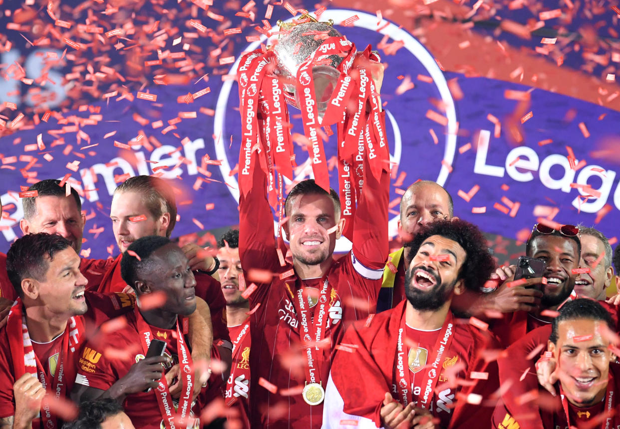 LIVERPOOL, ENGLAND - JULY 22: Jordan Henderson of Liverpool lifts The Premier League trophy following the Premier League match between Liverpool FC and Chelsea FC at Anfield on July 22, 2020 in Liverpool, England. Football Stadiums around Europe remain empty due to the Coronavirus Pandemic as Government social distancing laws prohibit fans inside venues resulting in all fixtures being played behind closed doors. (Photo by Laurence Griffiths/Getty Images)