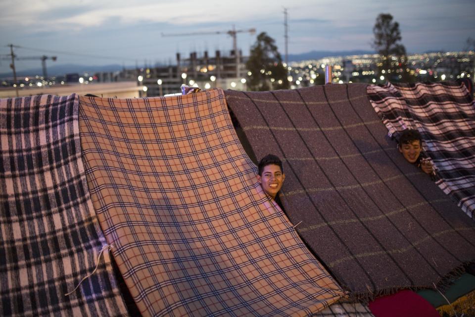 Central American migrants relax in their makeshift tents at a temporary shelter in Queretaro, Mexico, as they resume their journey north, Saturday, Nov. 10, 2018. Thousands of Central American migrants were back on the move toward the U.S. border Saturday, after dedicated Mexico City metro trains whisked them to the outskirts of the capital and drivers began offering rides north. (AP Photo/Rodrigo Abd)