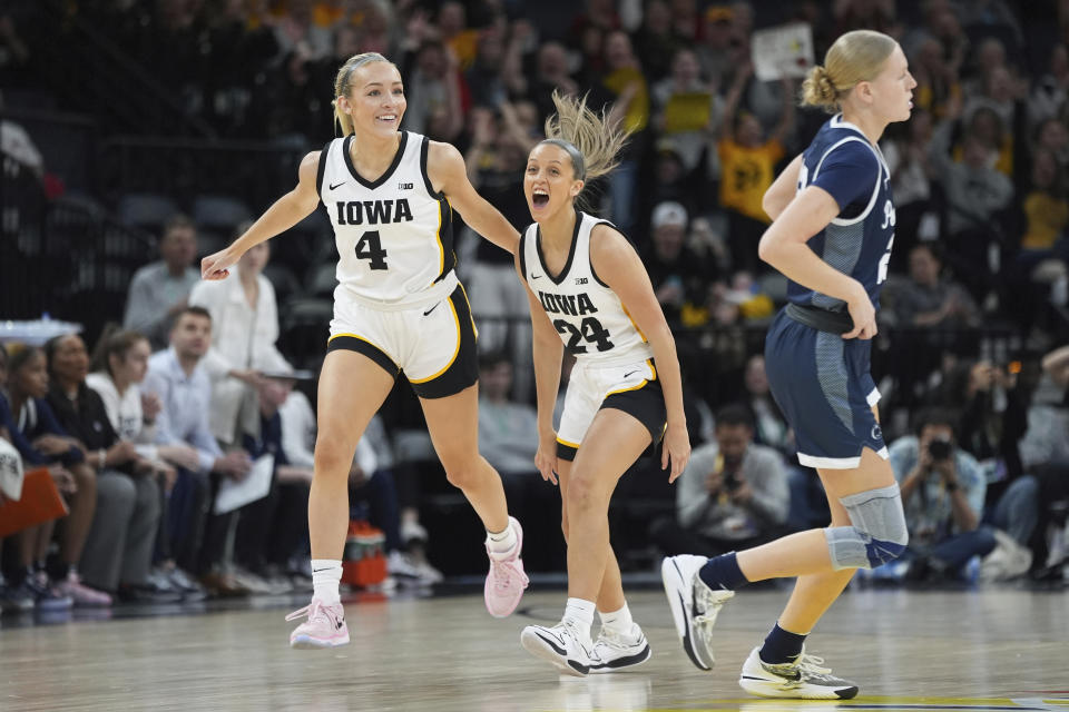 Iowa guard Gabbie Marshall (24) celebrates next to guard Kylie Feuerbach (4) after making a 3-point basket during the first half of an NCAA college basketball quarterfinal game against Penn State at the Big Ten women's tournament Friday, March 8, 2024, in Minneapolis. (AP Photo/Abbie Parr)