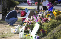 <p>Rachel Shuler of Burlington, Wash., takes a moment after placing a sign and balloons with her stepdaughter at a makeshift memorial on Sunday, Sept. 25, 2016, in Burlington, to the victims the victims killed in a mall shooting on Friday. (AP Photo/Stephen Brashear) </p>