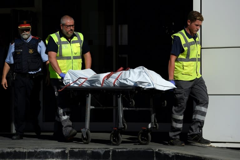 The body of a man who tried to attack a police station is carried out of the premises in Cornella near the northeastern Spanish city of Barcelona