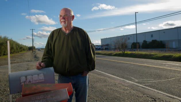 Darrell Schonauer on the edge of his property, across the street from the industrial building slated to become an Amazon Delivery Station. (Photo by <a href="http://www.chriskaufman.com/" rel="nofollow noopener" target="_blank" data-ylk="slk:Chris Kaufman;elm:context_link;itc:0;sec:content-canvas" class="link ">Chris Kaufman</a> for GeekWire.)