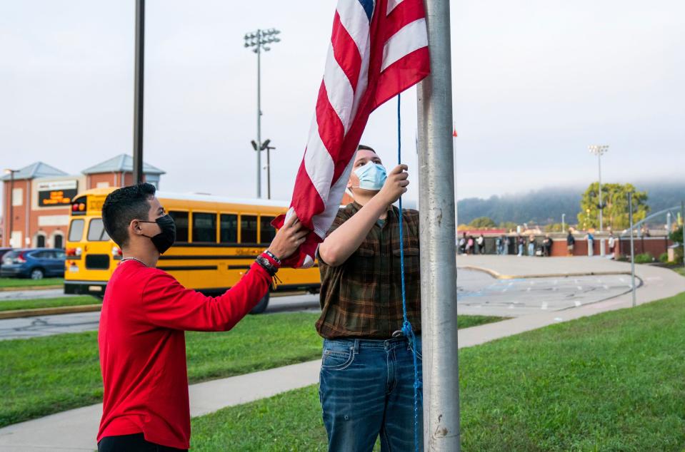 From left, 11th grader Ricardo Lopez and 10th grader Justin Couch raise the flag as a part of the ROTC's flag detail at Ambridge Area Senior High School on Sept. 7, the first day of Pennsylvania's mask mandate for K-12 schools and day care centers.