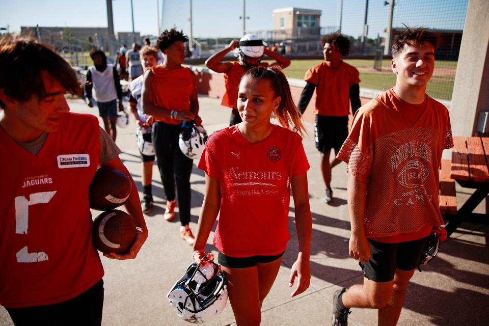 Gaby Rourke, center, talks to Sean Speed, left, after football practice Thursday at Atlantic Coast High School in Jacksonville.