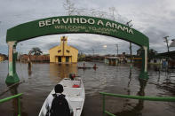 Residents navigate flooded streets in Anama, Amazonas state, Brazil, Thursday, May 13, 2021. (AP Photo/Edmar Barros)