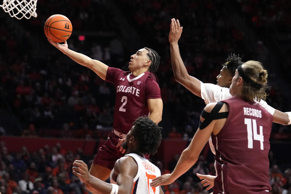 Colgate's Braeden Smith (2) drives to the basket past Illinois' Terrence Shannon Jr. as Keegan Records (14) and Quincy Guerrier watch during the second half of an NCAA college basketball game Sunday, Dec. 17, 2023, in Champaign, Ill. Illinois won 74-57. (AP Photo/Charles Rex Arbogast)