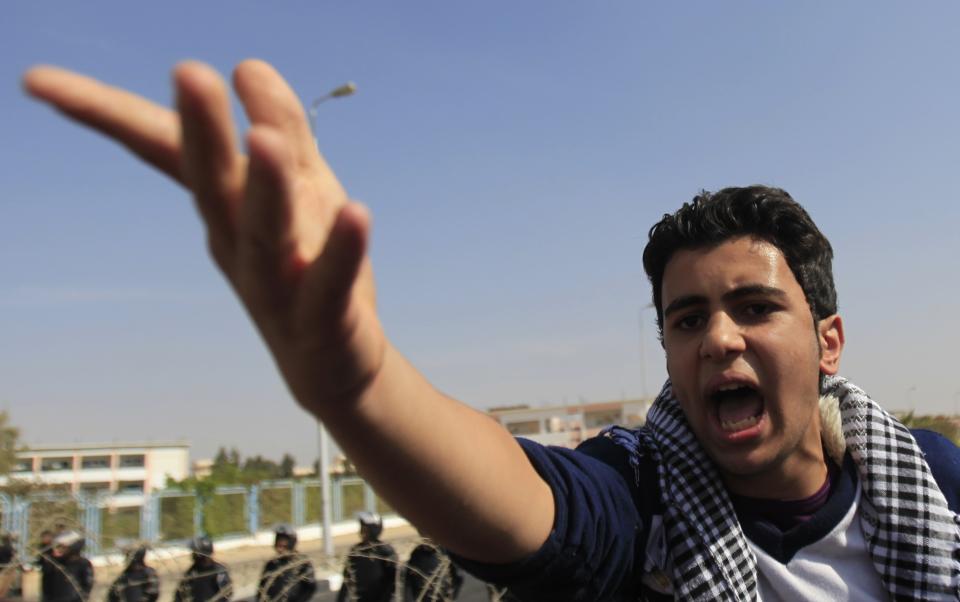 A supporter of the Muslim Brotherhood and ousted Egyptian President Mohamed Mursi shouts slogans against the military and interior ministry outside the police academy, where Mursi's trial took place, on the outskirts of Cairo