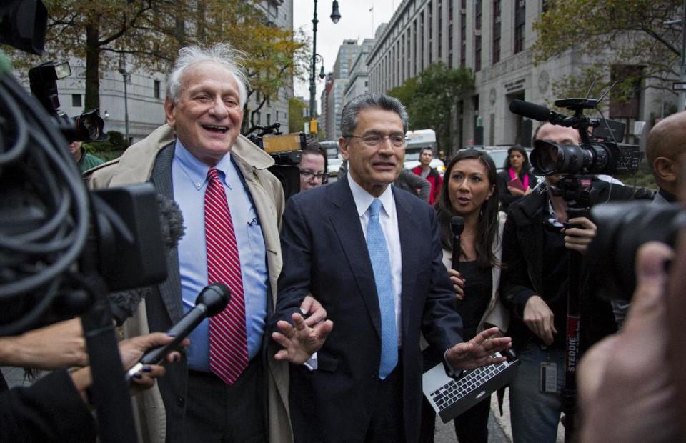 Rajat Gupta, center, asks members of the media to take a step back as he leaves federal court in New York on Wednesday, Oct. 24, 2012 after the former Goldman Sachs and Procter & Gamble Co. board member was sentenced Wednesday to 2 years in prison for feeding inside information about board dealings with a billionaire hedge fund owner who was his friend. At left is Gupta's attorney, Gary Naftalis. (AP Photo/Craig Ruttle)