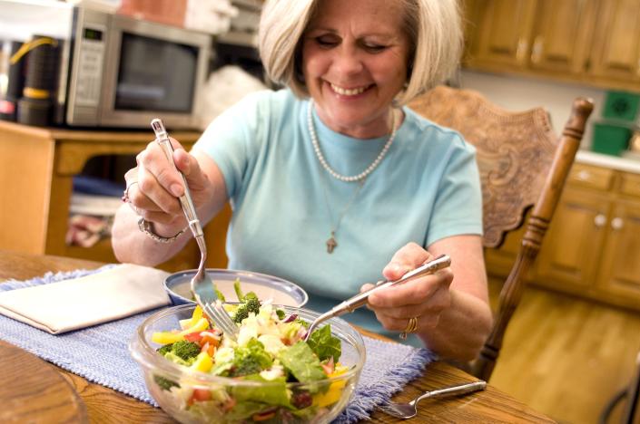 happy woman eating vegetable salad