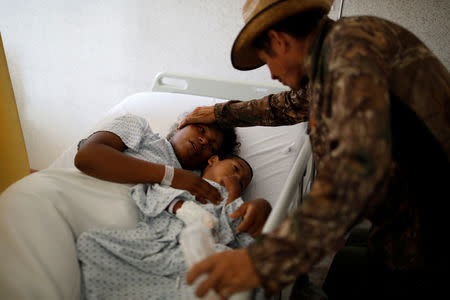 Honduran migrant Alvin Reyes, 39, visits his wife Erly Marcial, 21, who is eight months pregnant, at a hospital in Puebla, Mexico, November 12, 2018. REUTERS/Carlos Garcia Rawlins