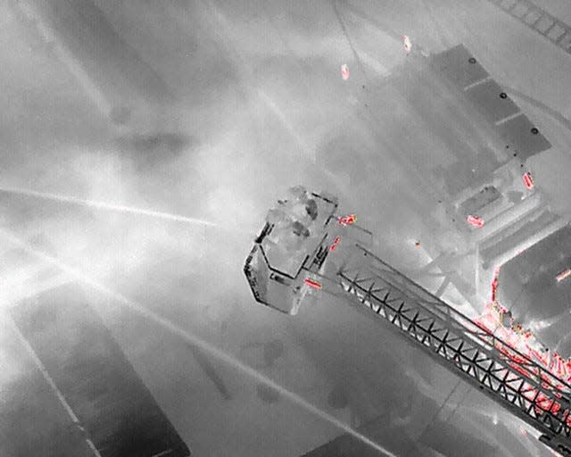 Firefighters are seen fighting the blaze in an infrared image taken by drone.