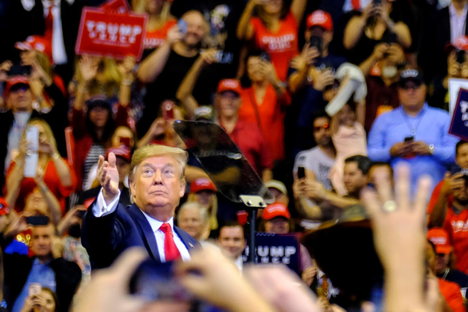 U.S. President Donald Trump tosses a Make America Great Again (MAGA) hat at a campaign rally where hundreds of supporters fill BB&T Center in Sunrise, Florida, U.S. November 26, 2019. Picture taken November 26, 2019. REUTERS/Maria Alejandra Cardona