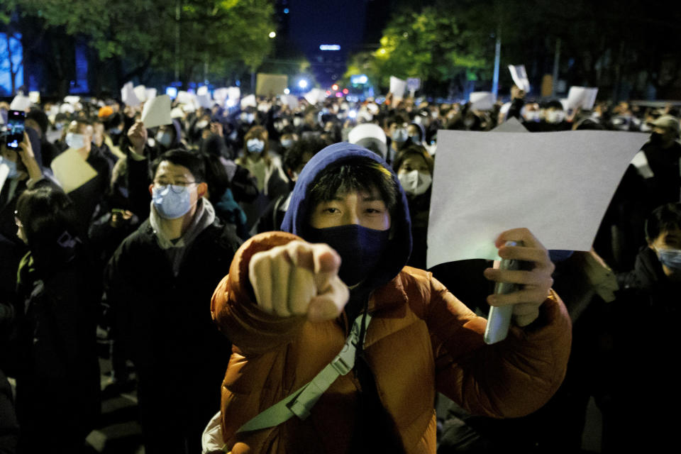 People in Beijing hold white sheets of paper in protest over COVID-19 restrictions after a vigil for the victims of a fire on Nov. 27, 2022.