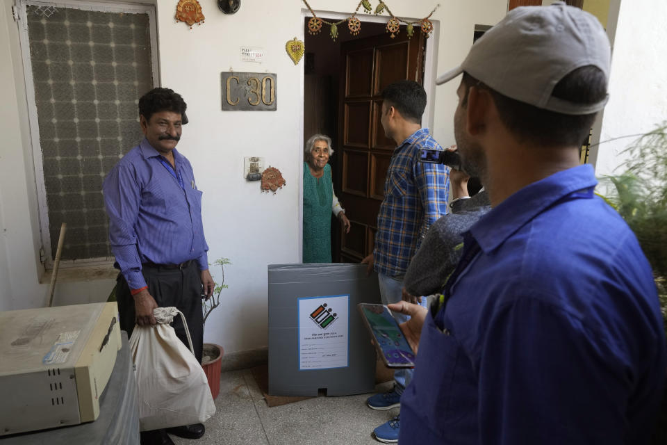 Vijay Lakshmi, 85, greets polling officers as they arrive at her residence, in New Delhi, India, Friday, May 17, 2024. To encourage and assist elderly persons to cast their votes, the chief electoral office of Delhi on Thursday initiated the home voting facility for the ongoing general parliamentary elections. (AP Photo/Manish Swarup)