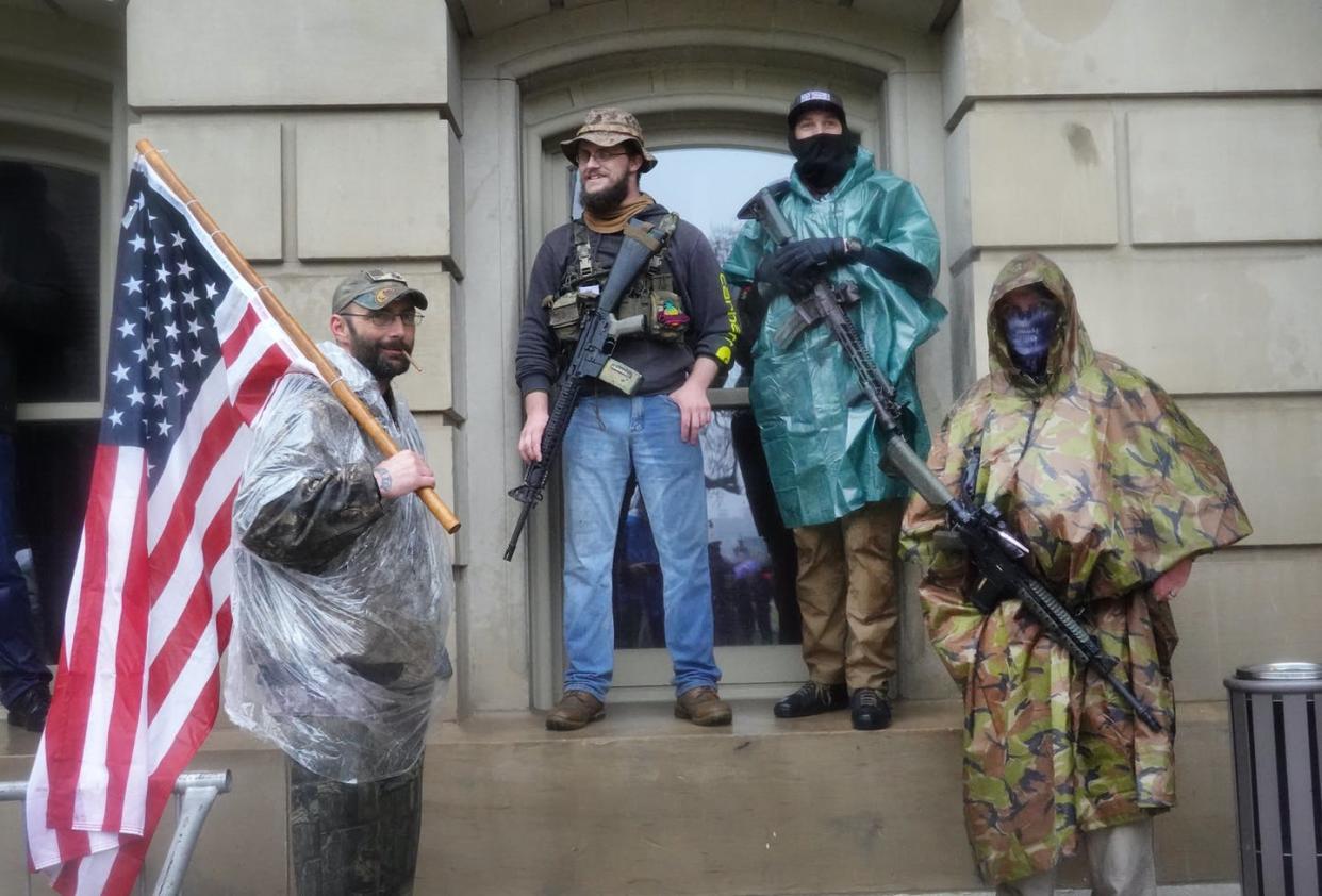 <span class="caption">Armed demonstrators attend a rally in front of the Michigan Capitol in Lansing to protest the governor's stay-at-home order on May 14, 2020. </span> <span class="attribution"><a class="link " href="https://www.gettyimages.com/detail/news-photo/armed-demonstrators-attend-a-rally-in-front-of-the-michigan-news-photo/1224848091" rel="nofollow noopener" target="_blank" data-ylk="slk:Scott Olson/Getty Images;elm:context_link;itc:0;sec:content-canvas">Scott Olson/Getty Images</a></span>
