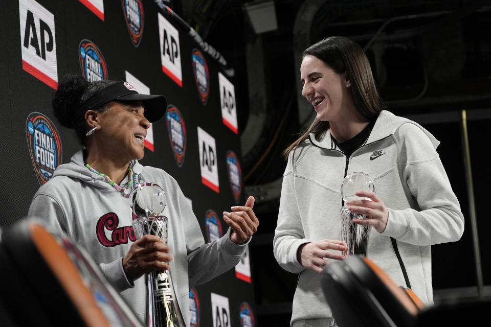 South Carolina head coach Dawn Staley, left, and Iowa's Caitlin Clark stand together on stage during a news conference announcing the AP NCAA Women's Coach and Player of the Year Thursday, April 4, 2024, in Cleveland. (AP Photo/Carolyn Kaster)