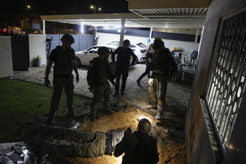 Israeli police officers inspect a damaged house after it was hit by a rocket fired from the Gaza Strip, in Sderot, Israel, Wednesday, May 10, 2023. (AP Photo/Ohad Zwigenberg)