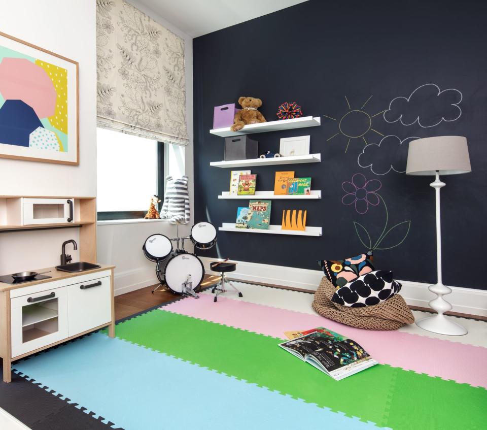 <p>In a children's game room from <a href="https://deringhall.com/interior-designers/matthew-caughy" rel="nofollow noopener" target="_blank" data-ylk="slk:Matthew Caughy;elm:context_link;itc:0;sec:content-canvas" class="link ">Matthew Caughy</a>, a chalkboard wall is equally fun and stylish.</p>